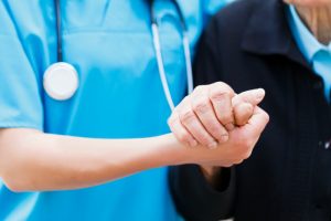 Caregiver holding patient's hand